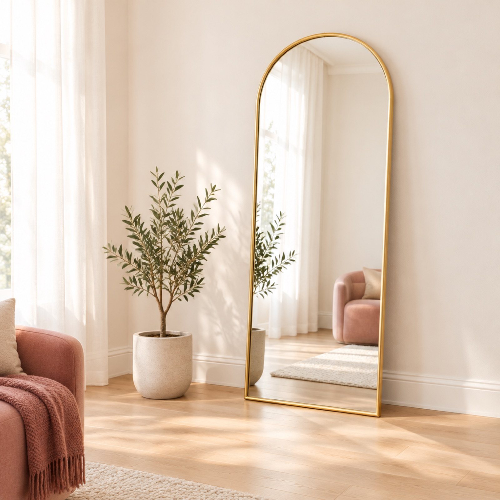An arched gold-framed floor mirror