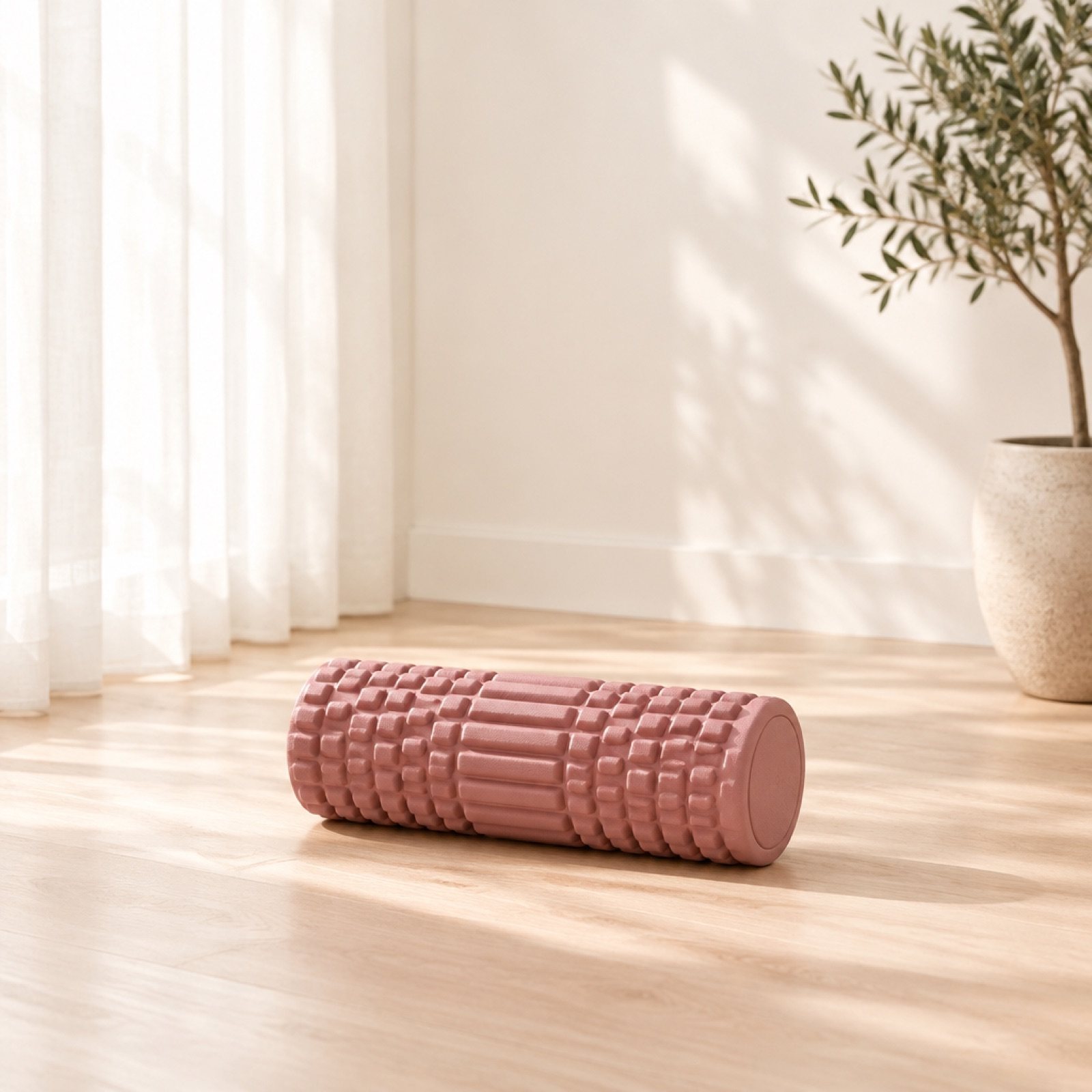 A textured dusty rose foam roller