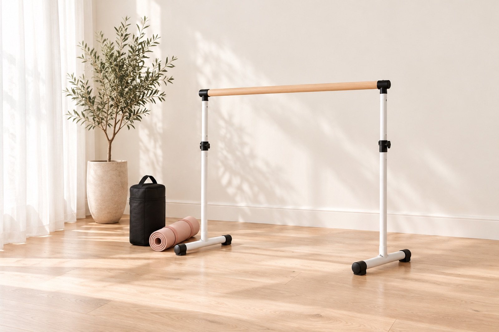 A compact folding portable ballet barre beside a carry bag and a rolled mat